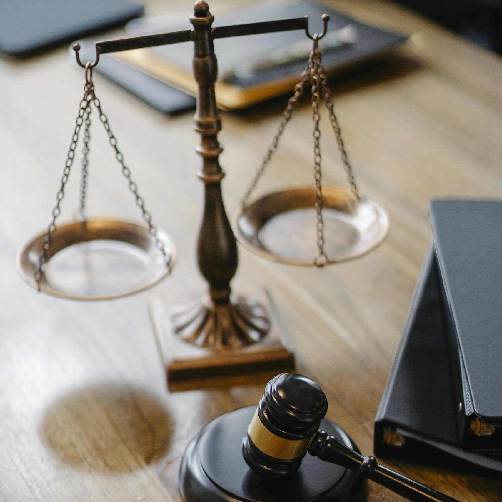 A striking image featuring a brass justice scale and gavel on a wooden desk, symbolizing law and justice.